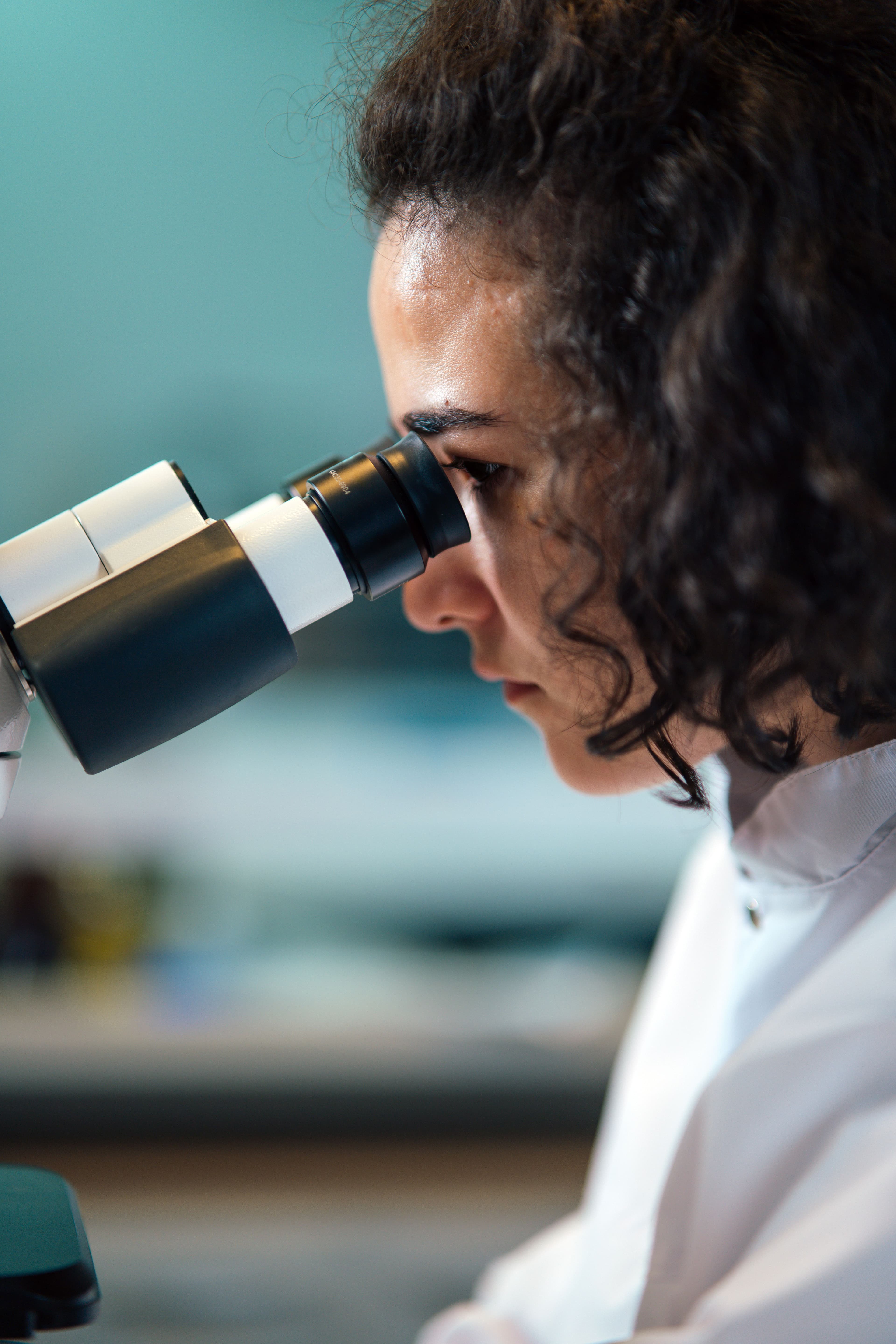 A woman working at a microscope in a laboratory